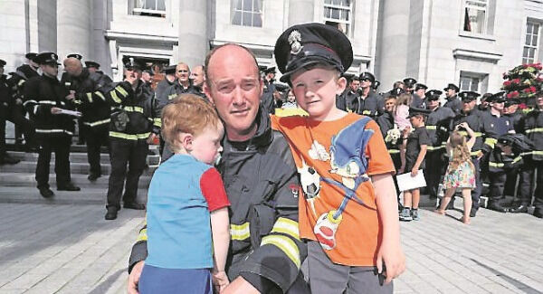 Firefighter Will Crowley with his sons Ethan, 3, and William, 6, outside City Hall.