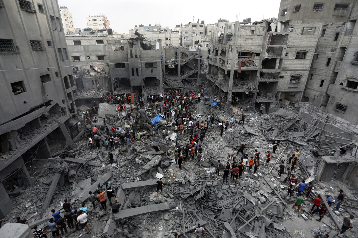 Palestinians inspect the damage after air strikes (Abed Khaled/AP)