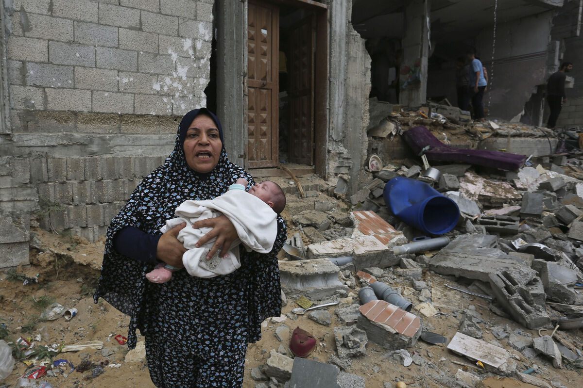 Palestinians evacuate a building destroyed in the Israeli bombardment of the Gaza Strip in Rafah.