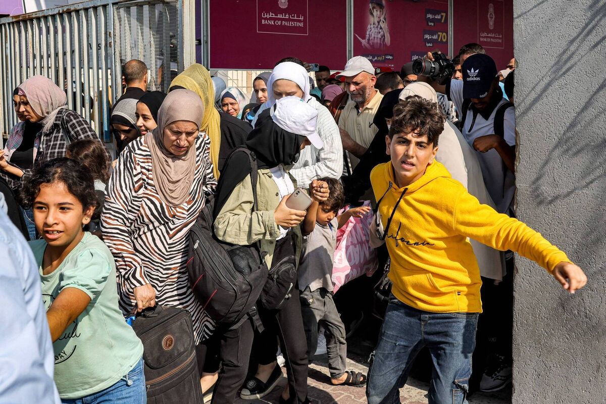 People walk through a gate to enter the Rafah border crossing to Egypt in the southern Gaza Strip on November 1, 2023. Picture: Mohammed ABED / AFP