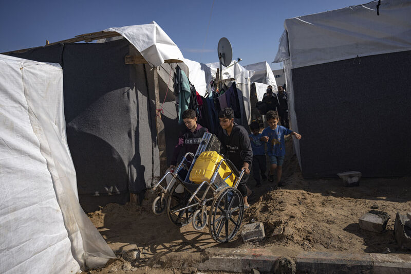 Palestinians displaced by the Israeli bombardment of the Gaza Strip carry supplies in a UNDP-provided tent camp in Khan Younis, Wednesday, Nov.15, 2023. (AP Photo/Fatima Shbair) Palestinians displaced by the Israeli bombardment of the Gaza Strip carry supplies in a UNDP-provided tent camp in Khan Younis, Wednesday, Nov.15, 2023. (AP Photo/Fatima Shbair)