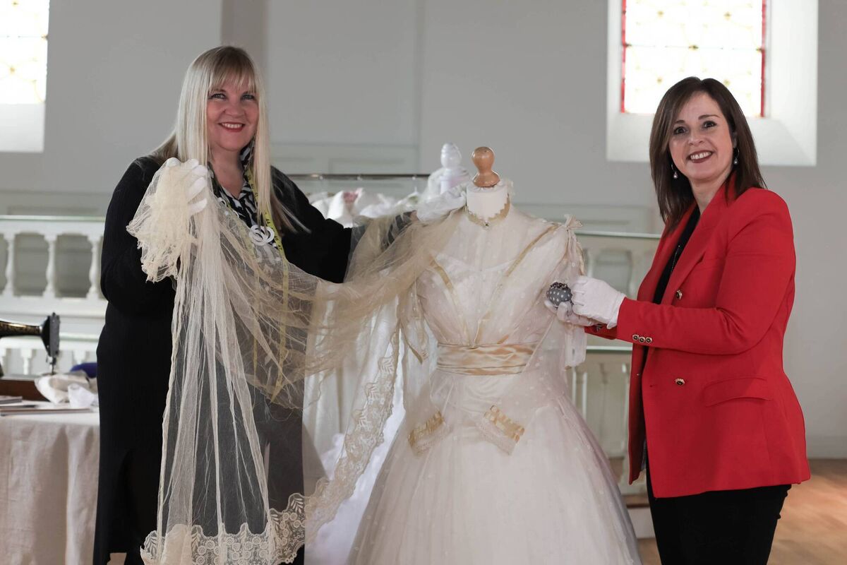 Handling the 1860s wedding dress with care and gloves are Gwen Mc Guirk and Michelle O'Mahony. Picture: Victoria Mannix Photography