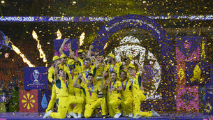Australia players celebrate with the trophy after winning the World Cup final (Aijaz Rahi/AP)