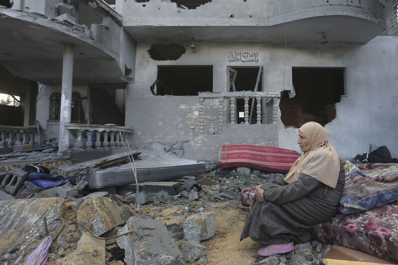 A Palestinian woman sits by houses destroyed in the Israeli bombardment of the Gaza Strip in Rafah on Monday. Photo: AP/Hatem Ali