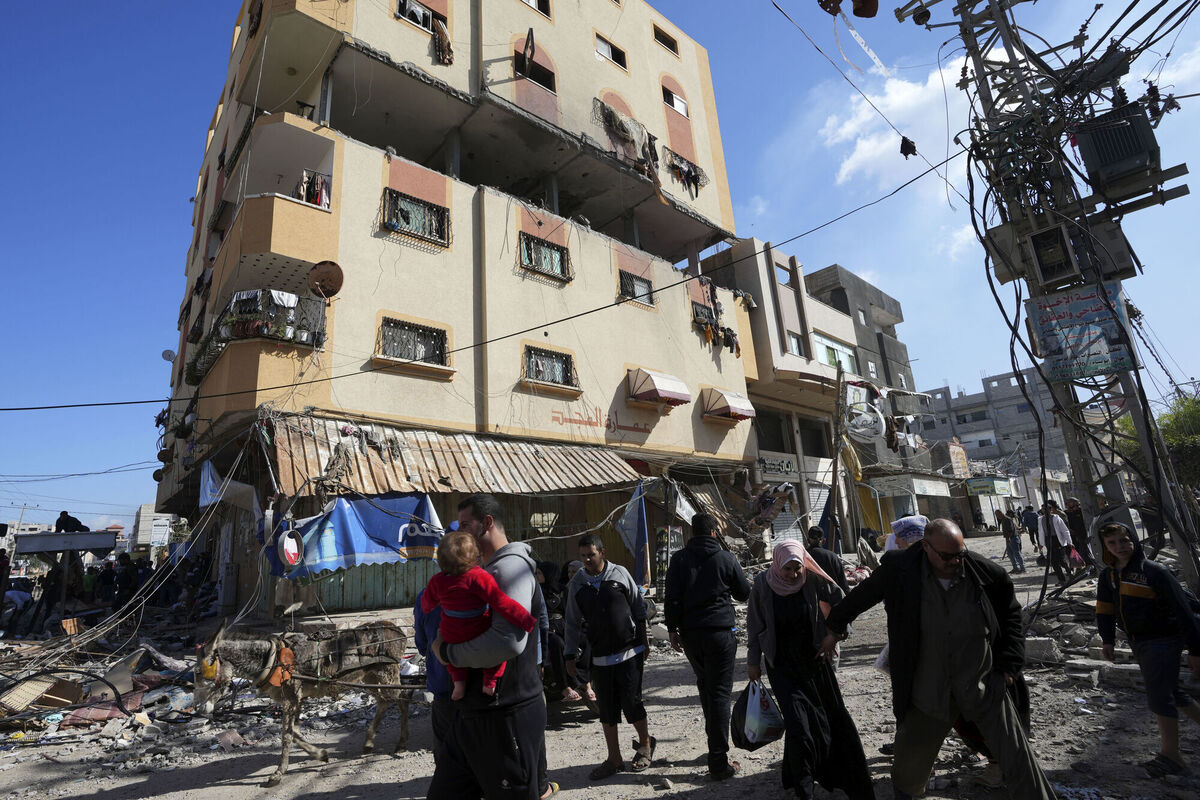 Palestinians gather in front of a building hit by an Israeli on the Gaza Strip at the Nusseirat refugee camp. Picture: AP Photo/Adel Hana