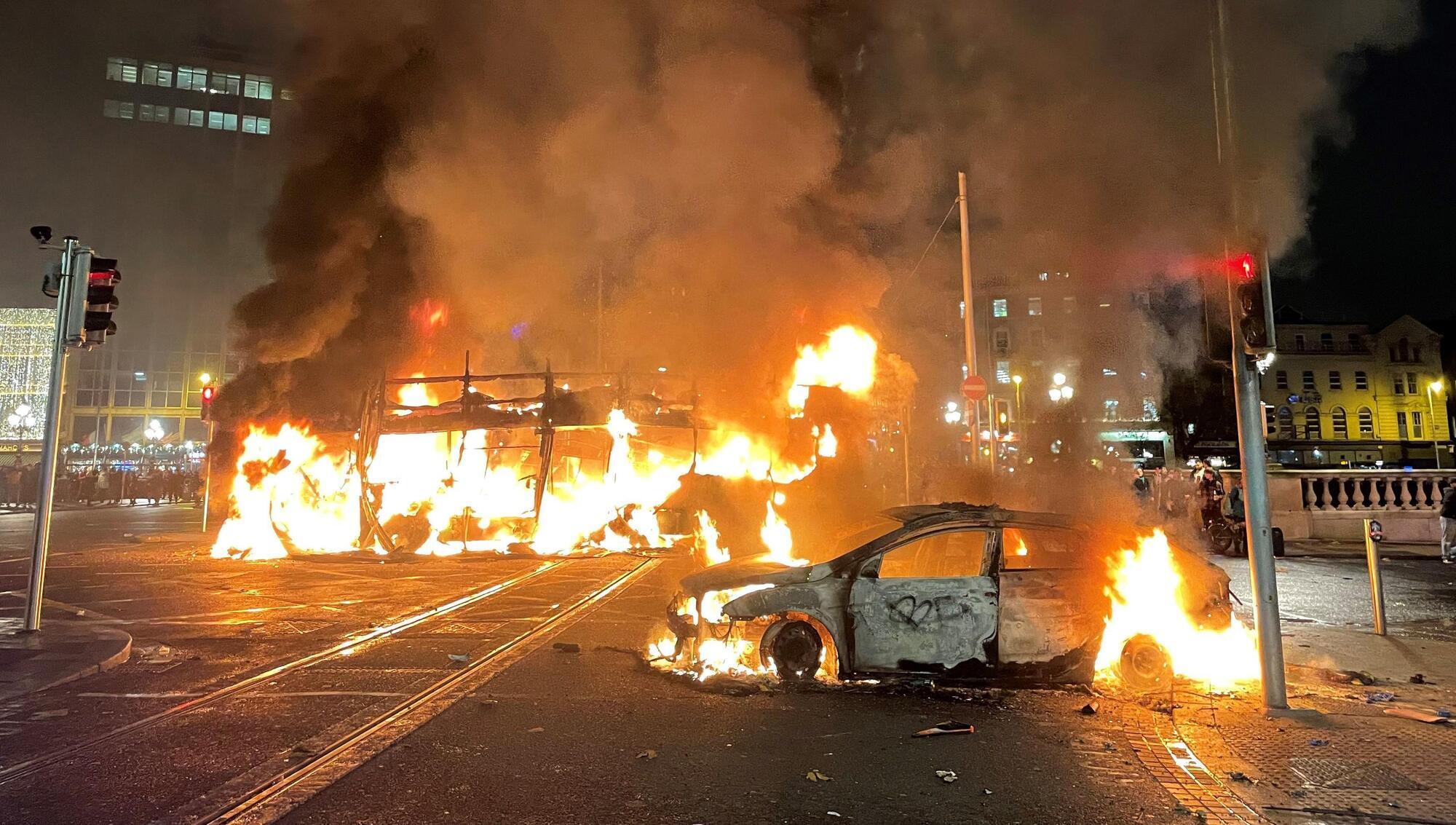 A bus and car on fire on O'Connell St in Dublin's city centre after violent scenes unfolded on Thursday evening. Picture: Brian Lawless/PA