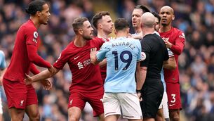 <p>Players surround referee Simon Hooper as tempers flare match at the Etihad Stadium.</p>