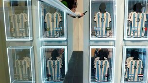 <p>Visitors look at a portion of the six 2022 World Cup match-worn shirts belonging to Argentina  great Lionel Messi during a Sotheby's auction media preview in New York City. 	Picture: Timothy A Clary/AFP via Getty Images</p>