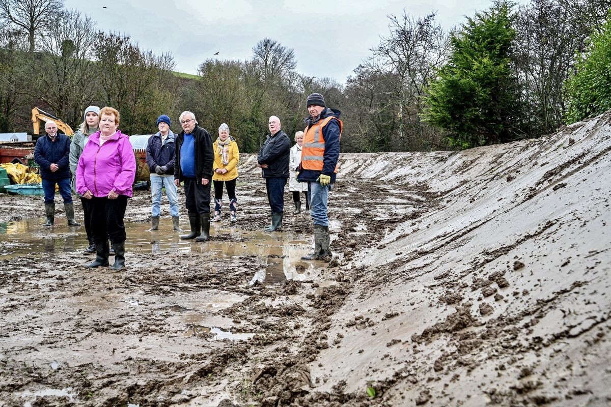 Residents in Ballinhassig, Cork stand together in front of an embankment they were forced to build themselves. Picture: Chani Anderson Residents in Ballinhassig, Cork stand together in front of an embankment they were forced to build themselves. Picture: Chani Anderson