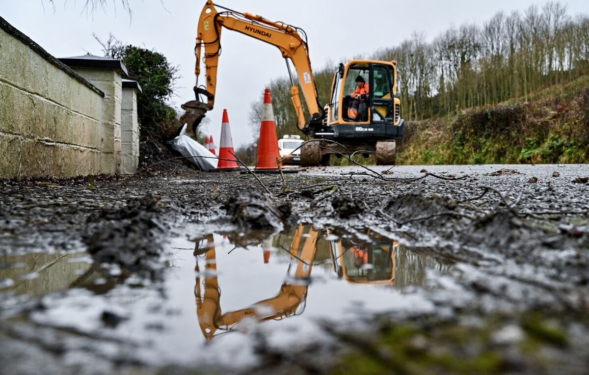 Residents in Ballinhassig, Cork stand together in front of an embankment they were forced to build themselves. Picture: Chani Anderson Residents in Ballinhassig, Cork stand together in front of an embankment they were forced to build themselves. Picture: Chani Anderson
