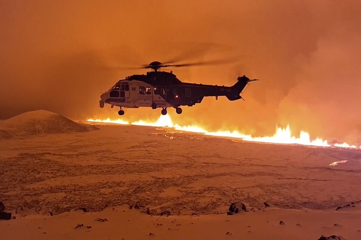 An Icelandic Coast Guard helicopter flying near magma running on a hill near Grindavik on Iceland's Reykjanes Peninsula. Picture: Icelandic Coast Guard via AP An Icelandic Coast Guard helicopter flying near magma running on a hill near Grindavik on Iceland's Reykjanes Peninsula. Picture: Icelandic Coast Guard via AP