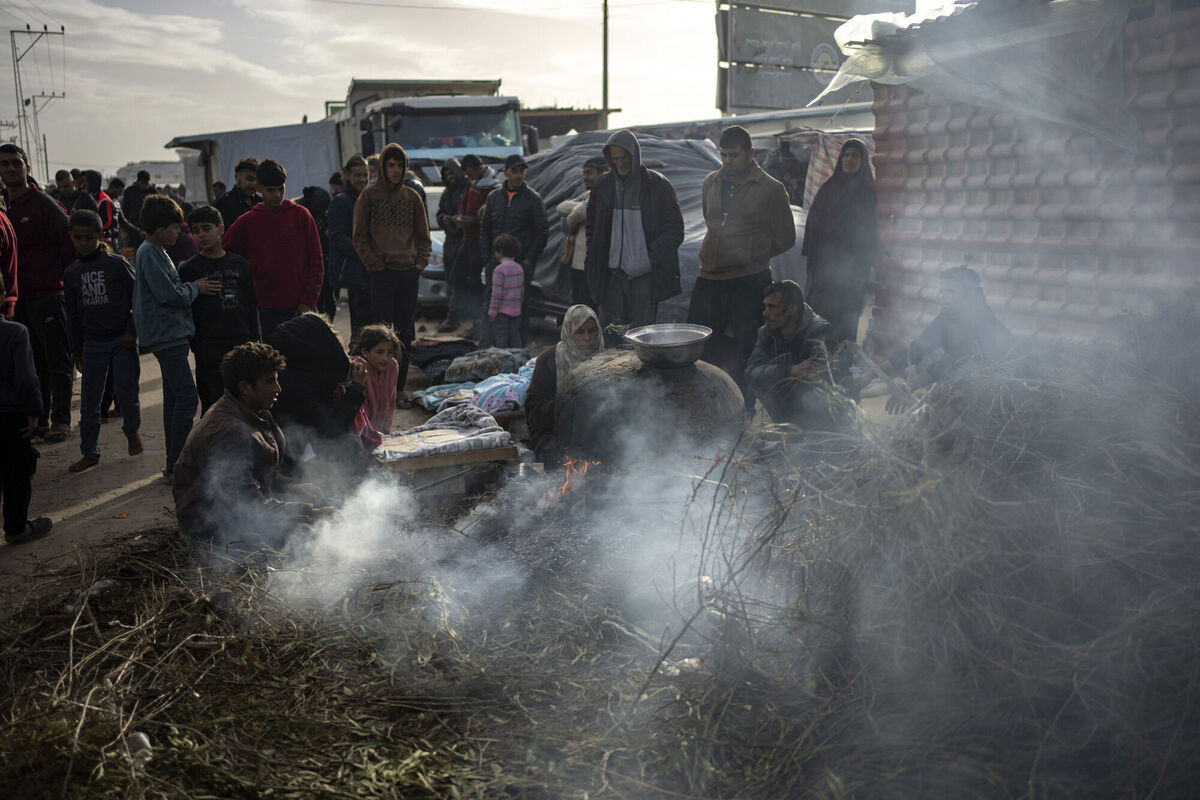 Palestinians displaced by the Israeli bombardment wait for their turn to bake bread at a makeshift tent camp in the Muwasi area in Rafah, Gaza Strip, 
