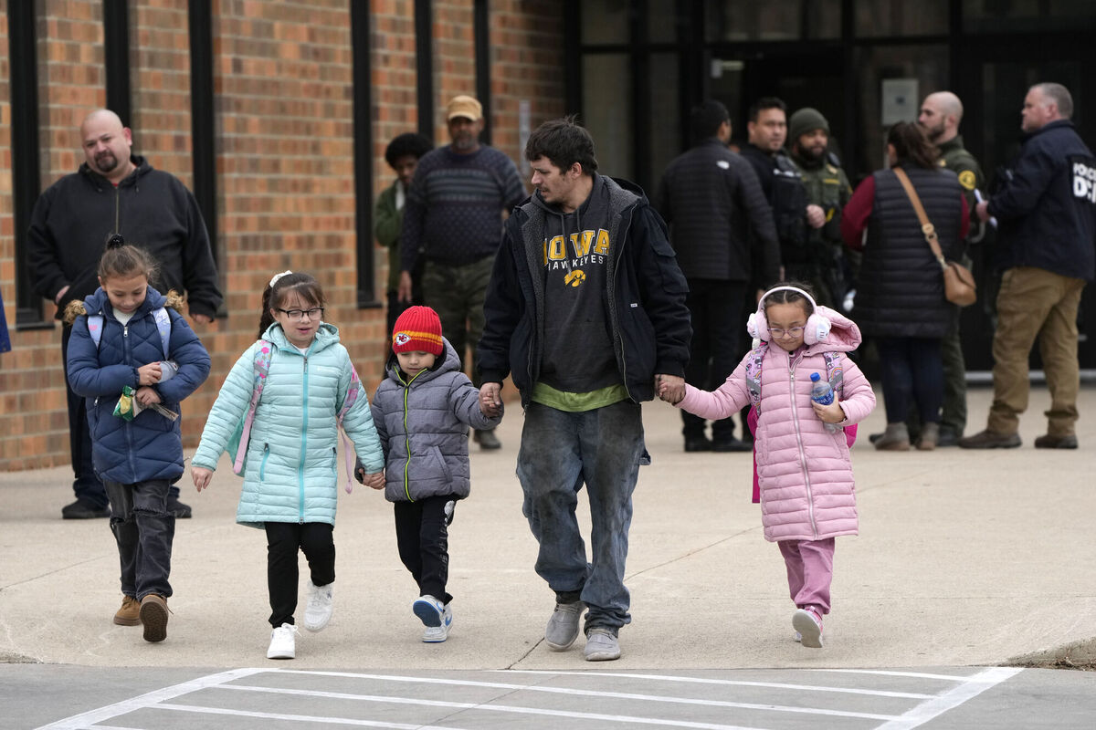 A man and children leave the McCreary Community Building after being reunited following a shooting at Perry High School. Picture: AP Photo/Charlie Neibergall