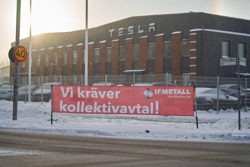 A banner from IF Metall union reading 'We Demand a Collective Agreement' during a labour protest outside the Tesla service center in Segeltorp, Sweden in December. Picture: Erik Flyg/Bloomberg A banner from IF Metall union reading 'We Demand a Collective Agreement' during a labour protest outside the Tesla service center in Segeltorp, Sweden in December. Picture: Erik Flyg/Bloomberg