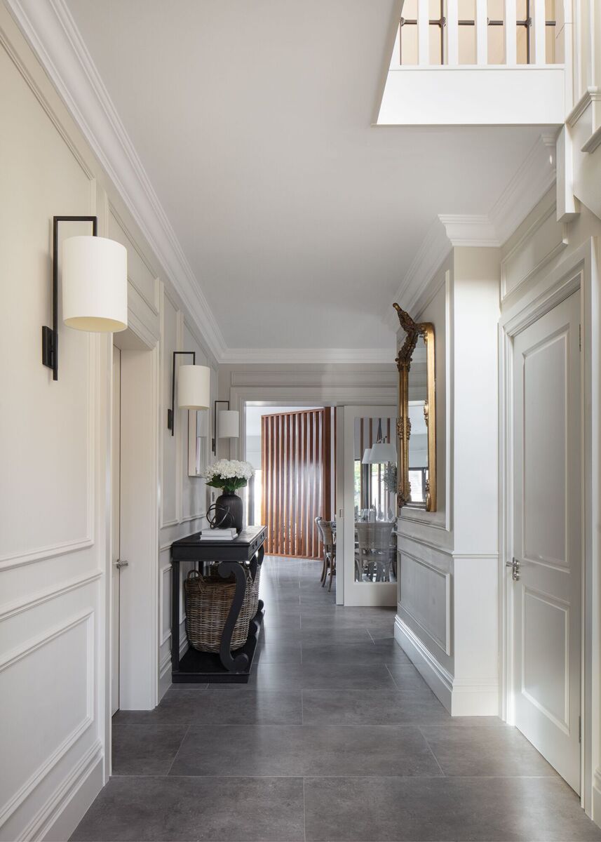  Wall fixtures provide ambient light in the hallway as part of the lighting plan in an interior design project by Sarah Louise Interiors.