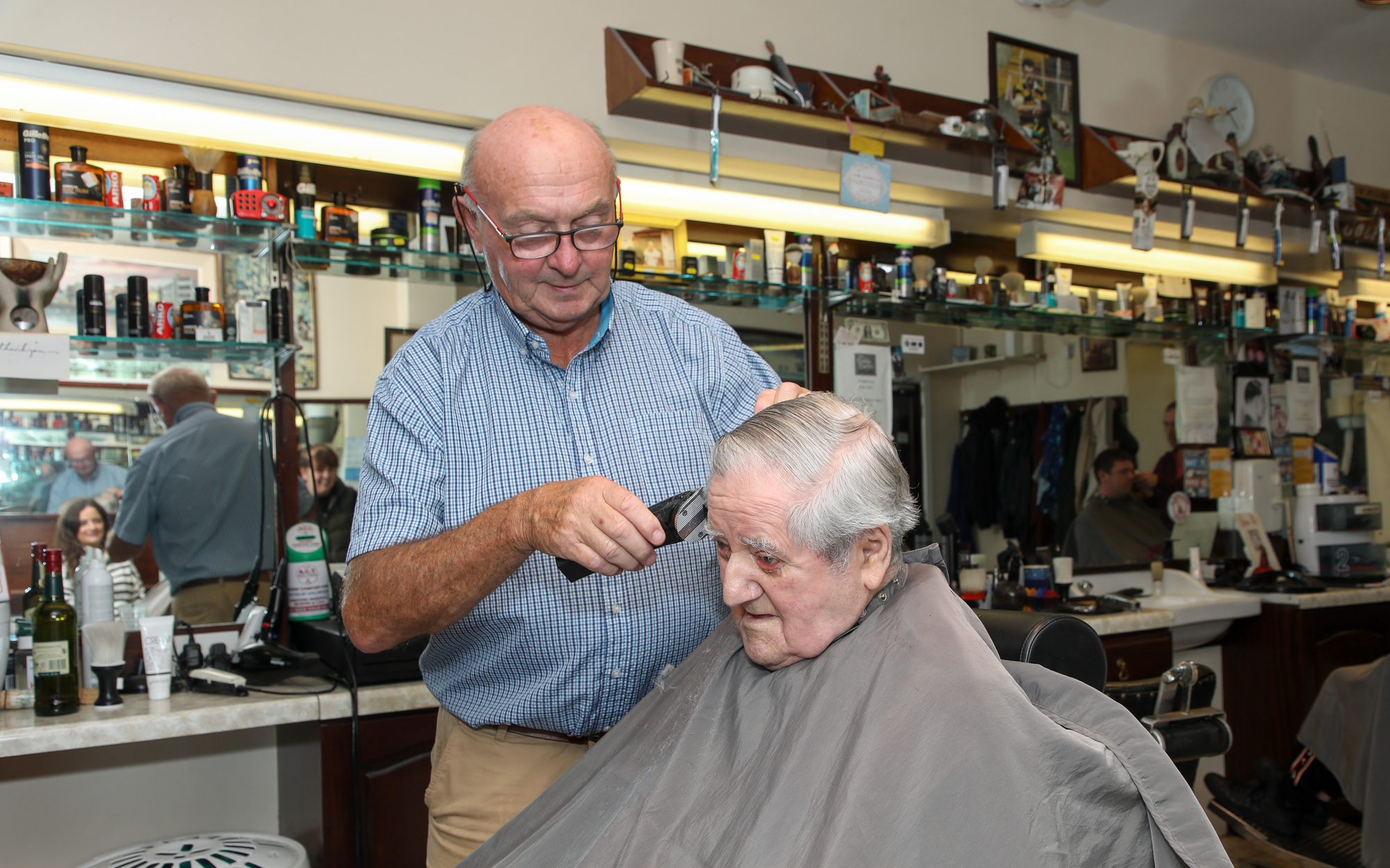 Michael O'Brien having his hair cut for a family wedding by barber Mick Moriarty (The Baldy Barber) at his salon on Great William O'Brien Street, Cork Picture: David Creedon
