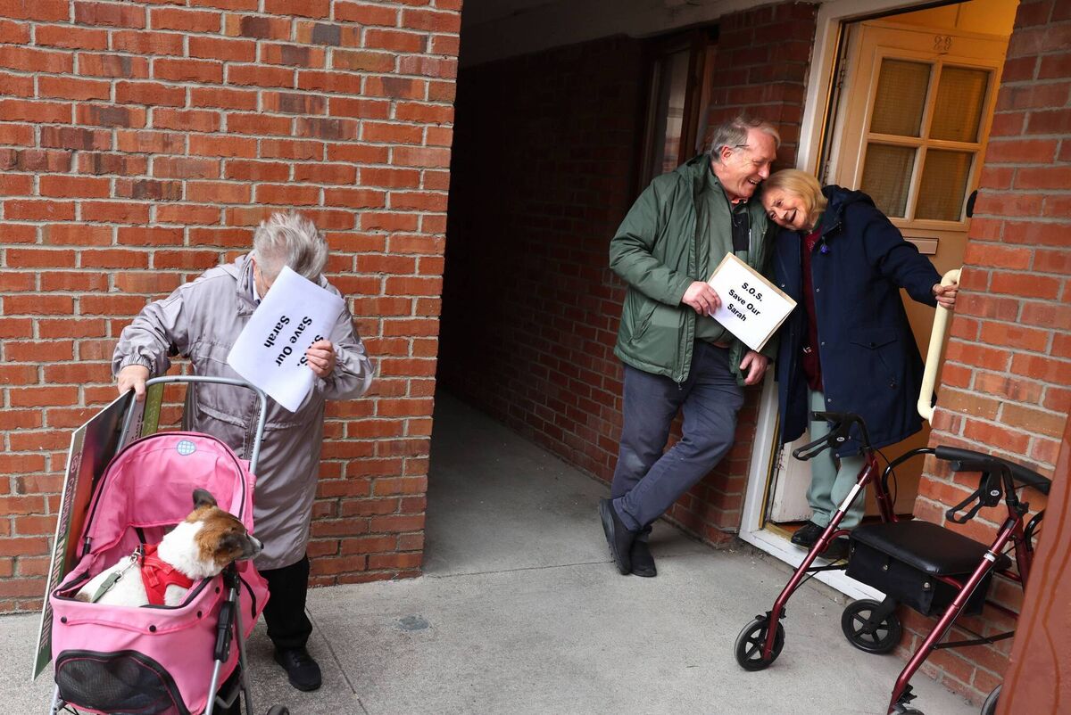 Sarah Cullen is at ease and supported by local shopkeeper, Noel Fleming, along with Mary Byrne and dog Victor, after experiencing an attempted robbery at her home the previous week. Picture: Dara Mac Dónaill/The Irish Times