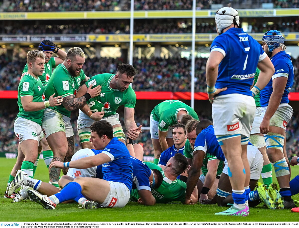 Jack Conan of Ireland, right, celebrates with team-mates Andrew Porter, middle, and Craig Casey, as they assist team-mate Dan Sheehan after scoring their side's third try. Photo by Ben McShane/Sportsfile