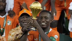 <p>Max-Alain Gradel and Ivory Coast President Alassane Ouattara raise the trophy.</p>