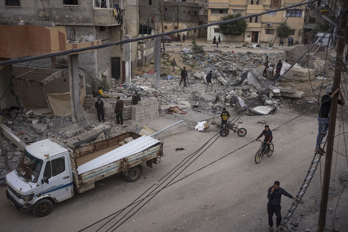 Palestinians inspect the rubble of the Hasouna family house, which was struck by an Israeli airstrike during an operation to rescue two hostages in Rafah