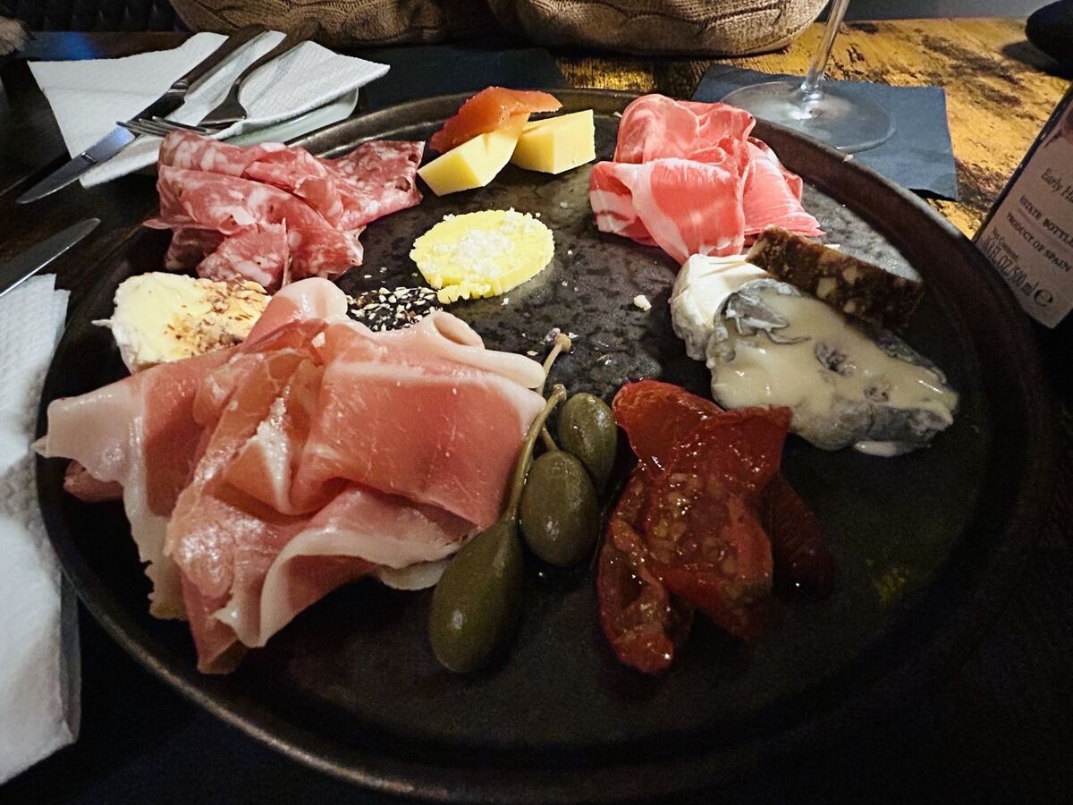 A sharing board of mixed cheeses and cured jamon and salami