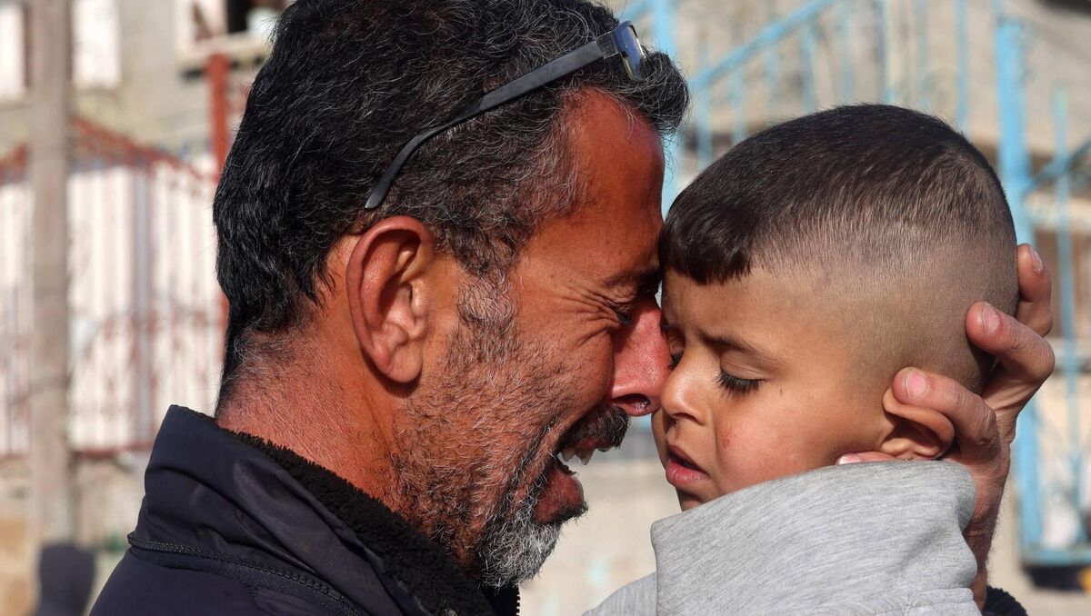 A Palestinian man holds a child as he mourns the death of twin babies Naeim and Wissam Abu Anza, killed in an overnight Israeli air strike, during their burial in Rafah in the southern Gaza Strip. Picture: Getty Images