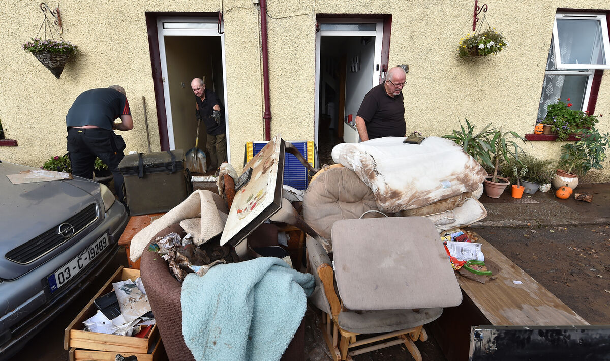  Edmund Aherne and his neighbour cleaning up after the floods caused by Storm Babet last October on Thomas Street, Midleton, Co Cork. Picture: Dan Linehan