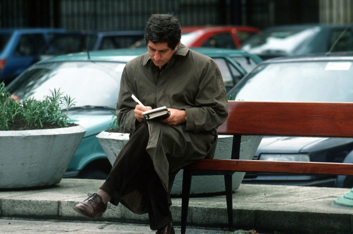 Charlie Bird writes up his notes while sitting on a bench outside the Dáil in 1991 Picture: RollingNews.ie Charlie Bird writes up his notes while sitting on a bench outside the Dáil in 1991 Picture: RollingNews.ie