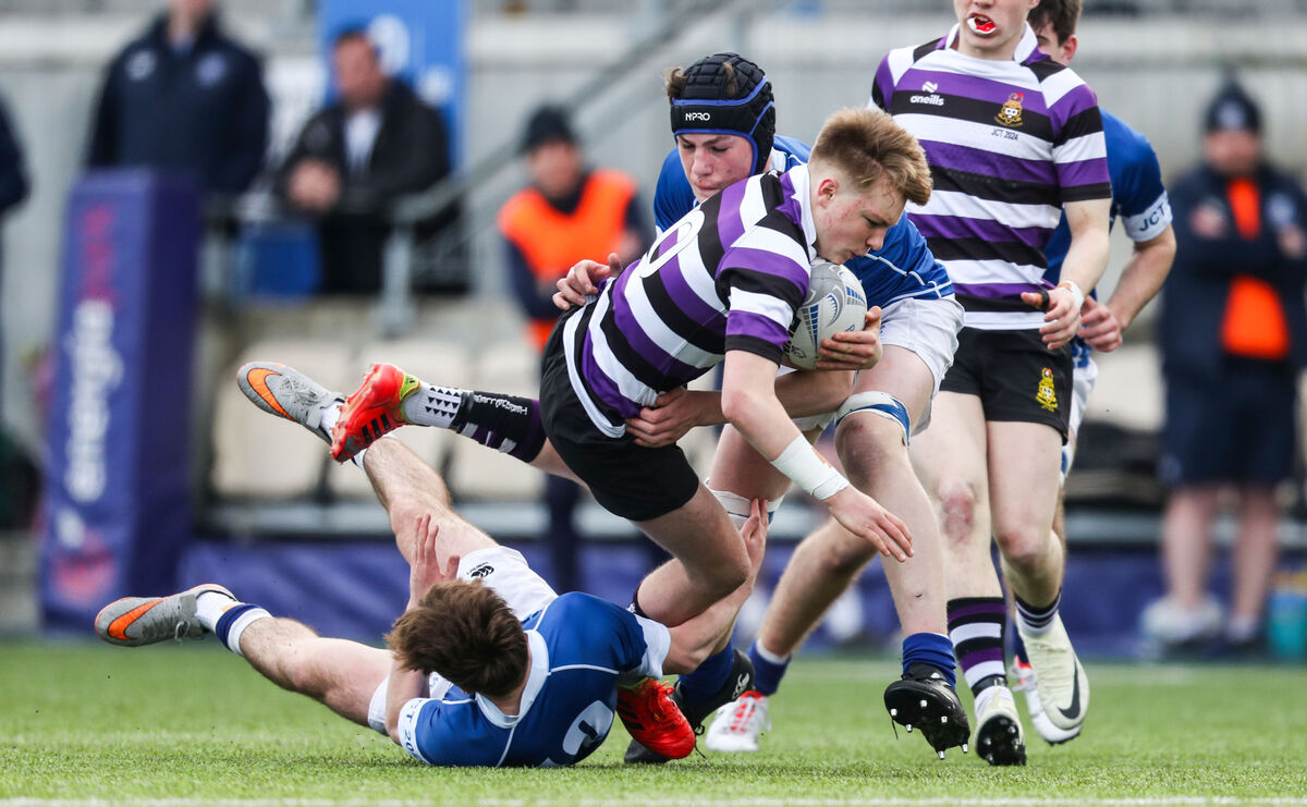 Terenure's Ewan McGinty is tackled by Nicolas Sheehan and James Whitty of St Mary's Terenure's Ewan McGinty is tackled by Nicolas Sheehan and James Whitty of St Mary's