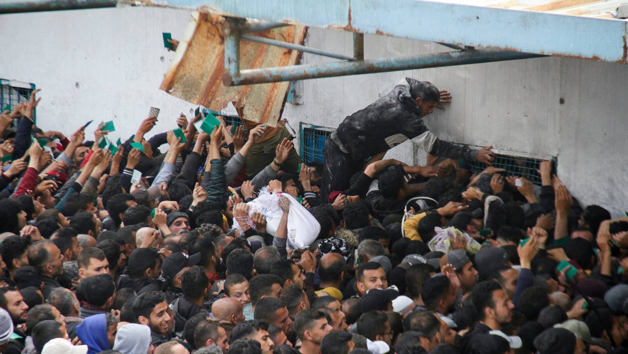 Palestinians gather to receive aid outside an UNRWA warehouse as Gaza residents face crisis levels of hunger, amid the ongoing conflict between Israel and Hamas, in Gaza City. Picture: Reuters/Mahmoud Issa