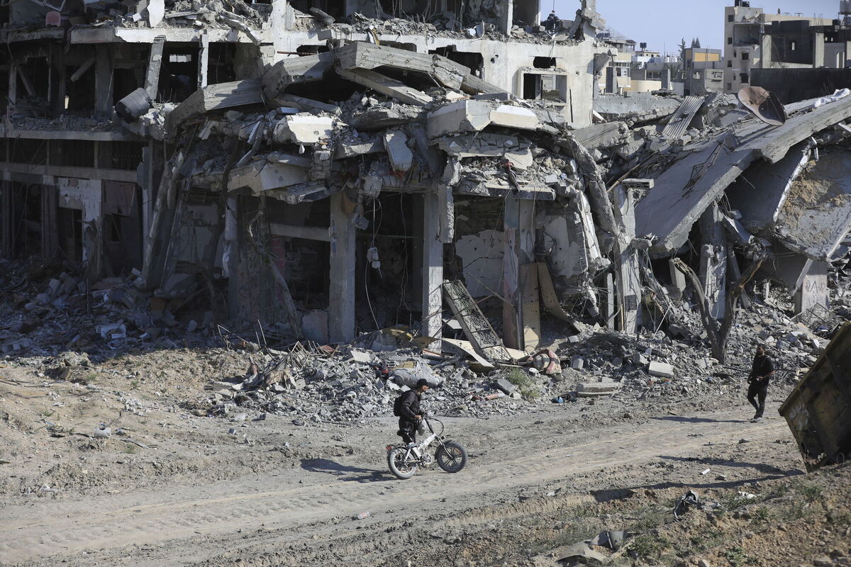 Palestinians walk through the destruction left by the Israeli air and ground offensive after they withdrew from Khan Younis, southern Gaza Strip, Sunday, April 7, 2024. (AP Photo/Ismael Abu Dayyah)