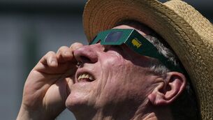 <p>A patron look up at the sun during an solar eclipse during a practice round  for the Masters at Augusta National Golf Club on Monday. Picture: Matt Slocum/AP</p>