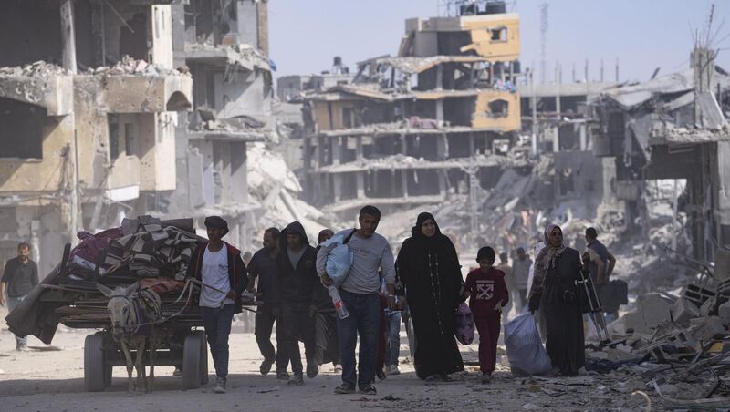 Palestinians walk through the destruction in the wake of an Israeli air and ground offensive in Khan Younis, southern Gaza Strip, on Monday. Picture: Fatima Shbair/AP Palestinians walk through the destruction in the wake of an Israeli air and ground offensive in Khan Younis, southern Gaza Strip, on Monday. Picture: Fatima Shbair/AP