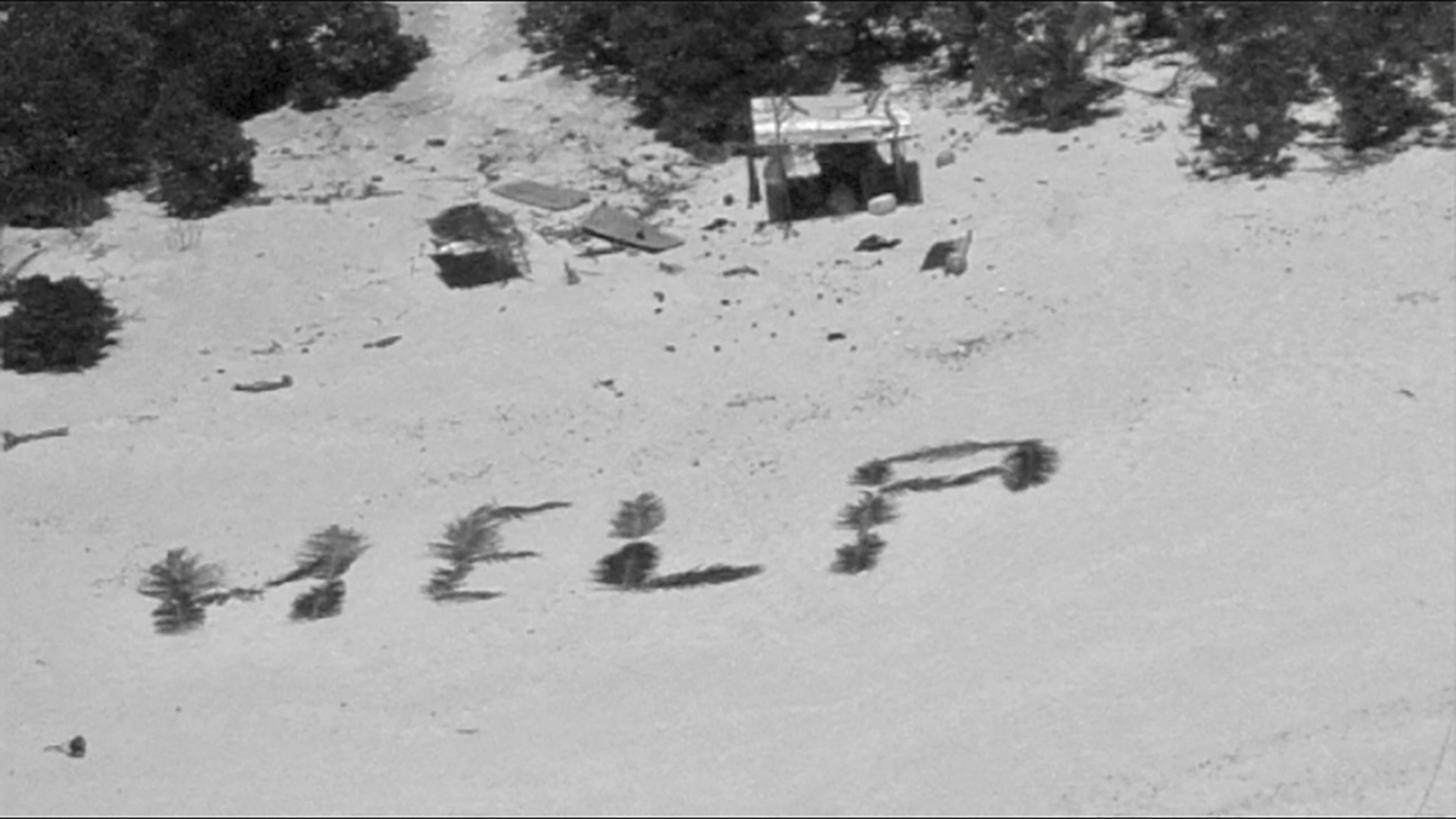 Three men rescued from Pacific island after creating ‘help’ sign on beach