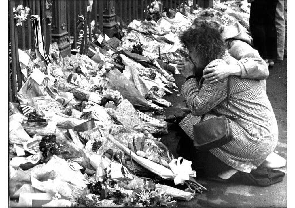 A woman kneels by floral tributes at the gate of the Hillsborough ground. Picture: David Giles/PA A woman kneels by floral tributes at the gate of the Hillsborough ground. Picture: David Giles/PA