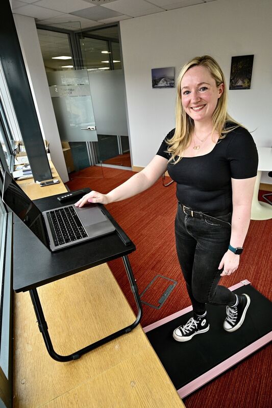 Irish Examiner journalist Denise O’Donoghue puts a walking pad under her standing desk. Picture Chani Anderson