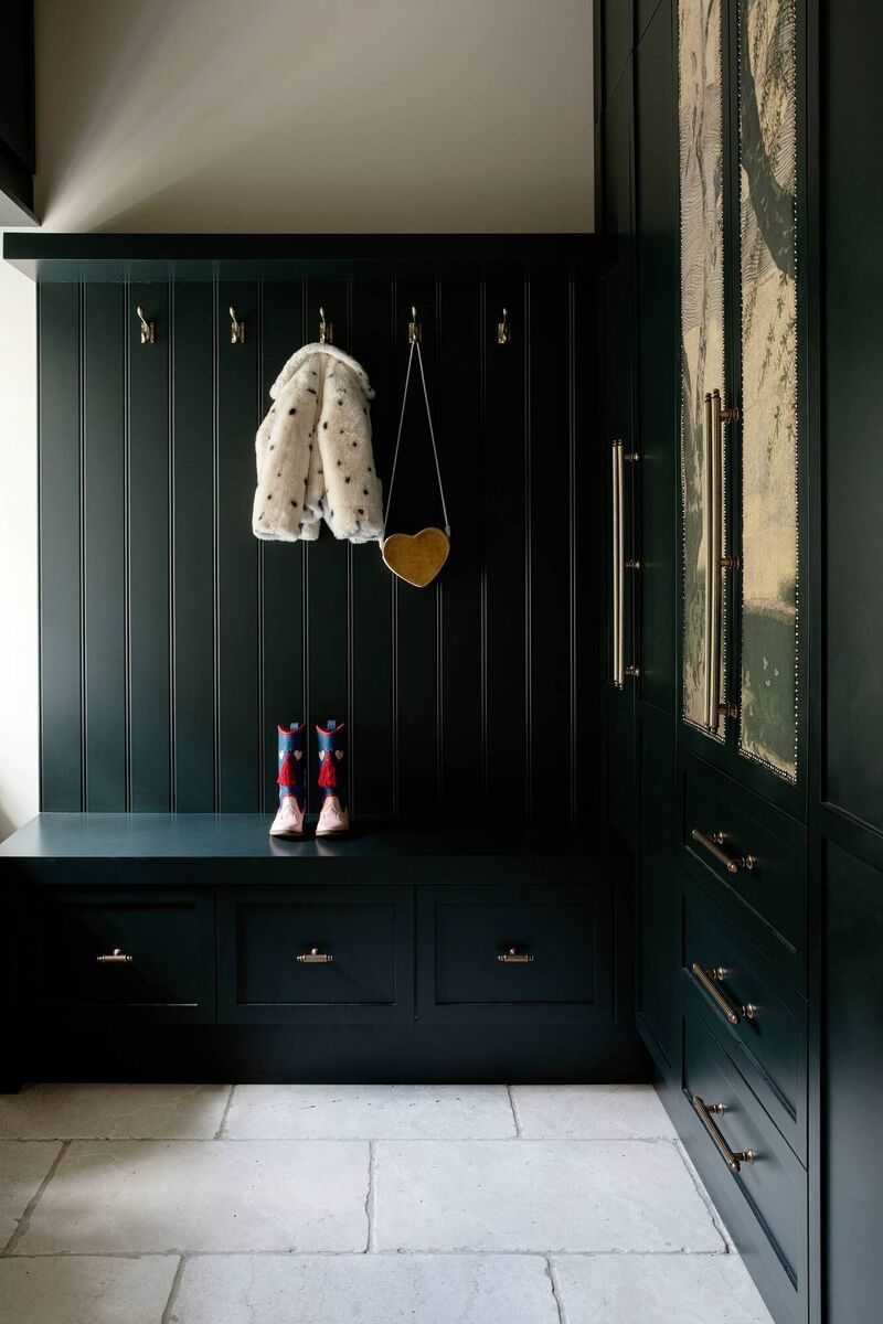 A traditional-style mudroom adds storage and is painted in Green Smoke from Farrow &amp; Ball.