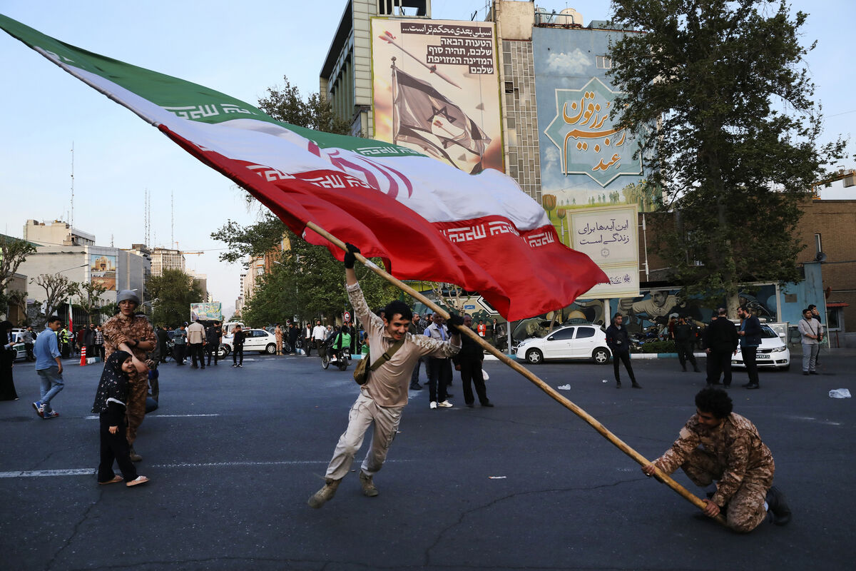 Demonstrators wave a huge Iranian flag backdropped by a building emblazoned with anti-Israeli messages, in Tehran. Picture: AP Photo/Vahid Salemi Demonstrators wave a huge Iranian flag backdropped by a building emblazoned with anti-Israeli messages, in Tehran. Picture: AP Photo/Vahid Salemi