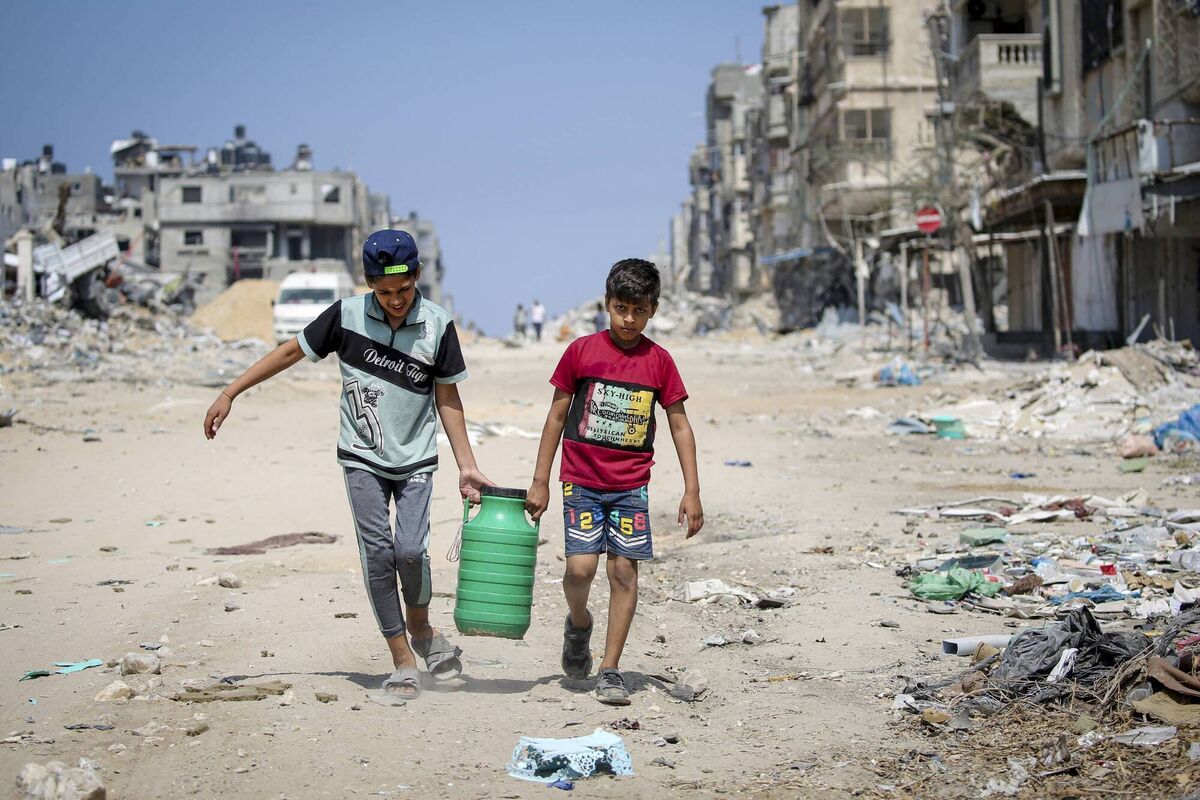 Children carry water as they walk past buildings destroyed during Israeli bombardment in Khan Yunis, on the southern Gaza Strip. Picture: Getty Images Children carry water as they walk past buildings destroyed during Israeli bombardment in Khan Yunis, on the southern Gaza Strip. Picture: Getty Images