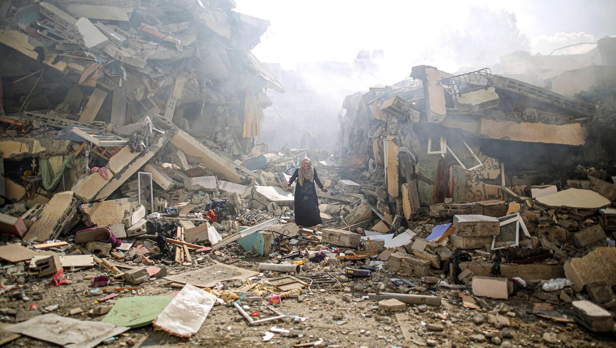A resident of al-Zahra walks through the rubble of homes destroyed in Israeli airstrikes. The strikes hit around 25 apartment blocks in the university and residential neighborhood.