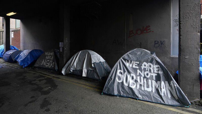 People walking past tents housing asylum seekers near to the International Protection Office, in Dublin. Picture: Niall Carson/PA Wire