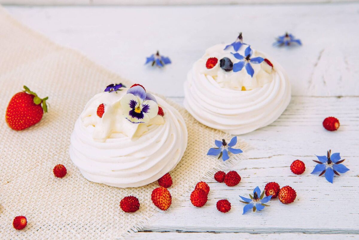 Violas and borage flowers on a meringue dessert. 