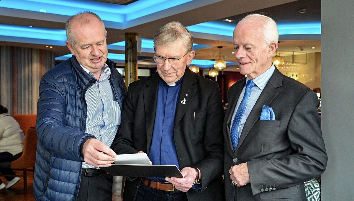 Bishop John Buckley, centre, and Paddy O’Brien taking a walk down memory lane with retired press photographer Denis Minihane. Picture: Chani Anderson
