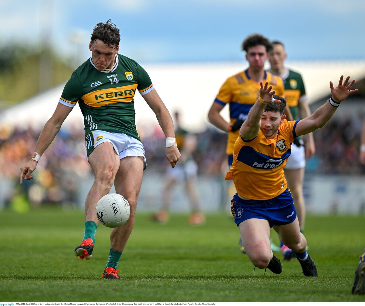 David Clifford of Kerry kicks a point despite the efforts of Ronan Lanigan of Clare. Photo by Brendan Moran/Sportsfile