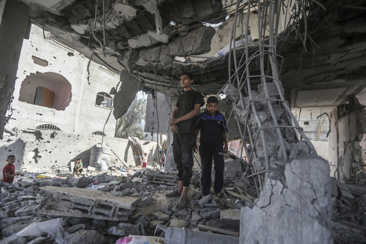 Palestinians stand in the ruins of the Chahine family home, after an overnight Israeli strike that killed at least two adults and five boys and girls under the age of 16 in Rafah, southern Gaza Strip on Friday (Picture: AP Photo/Ismael Abu Dayyah)