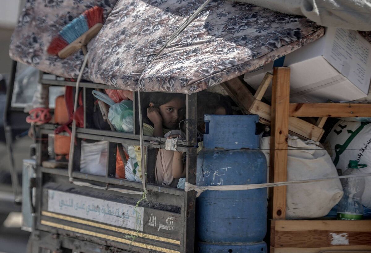 A child sits back on a truck as Palestinians with their packed belongings, continue to depart from the eastern neighborhoods of the city due to ongoing Israeli attacks in Rafah, Gaza on May 8, 2024. (Photo by Ali Jadallah/Anadolu via Getty Images)