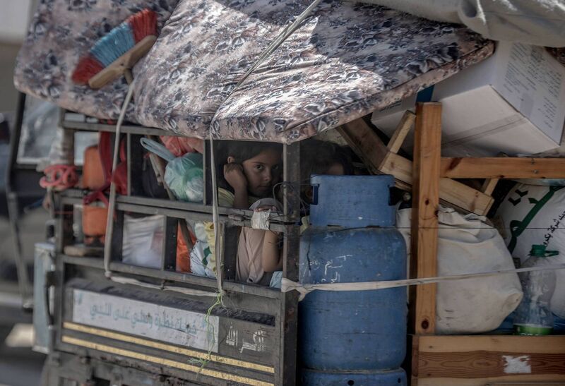 A child sits back on a truck as Palestinians with their packed belongings, continue to depart from the eastern neighborhoods of the city due to ongoing Israeli attacks in Rafah, Gaza on May 8, 2024. (Photo by Ali Jadallah/Anadolu via Getty Images)