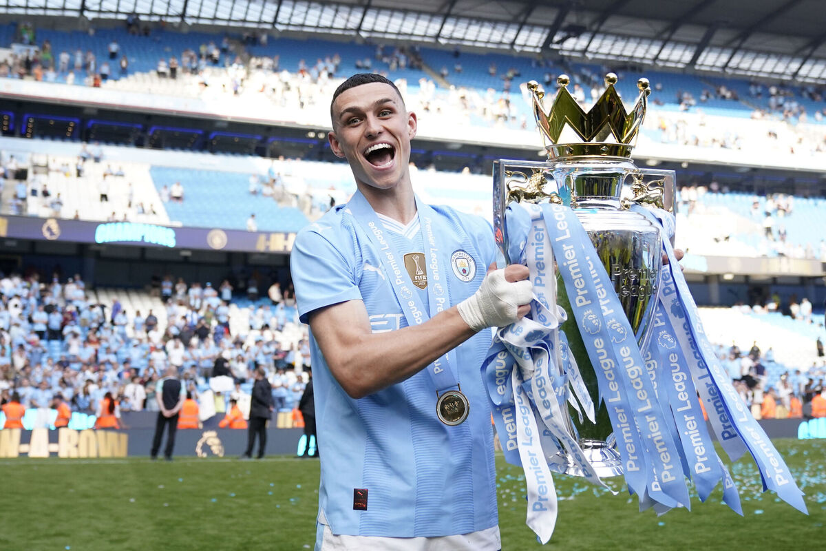 Manchester City's Phil Foden celebrates with the Premier League trophy 