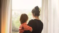 Mother and son looking out of window