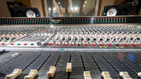 Wide angle view of sliders on a music recording mixing desk